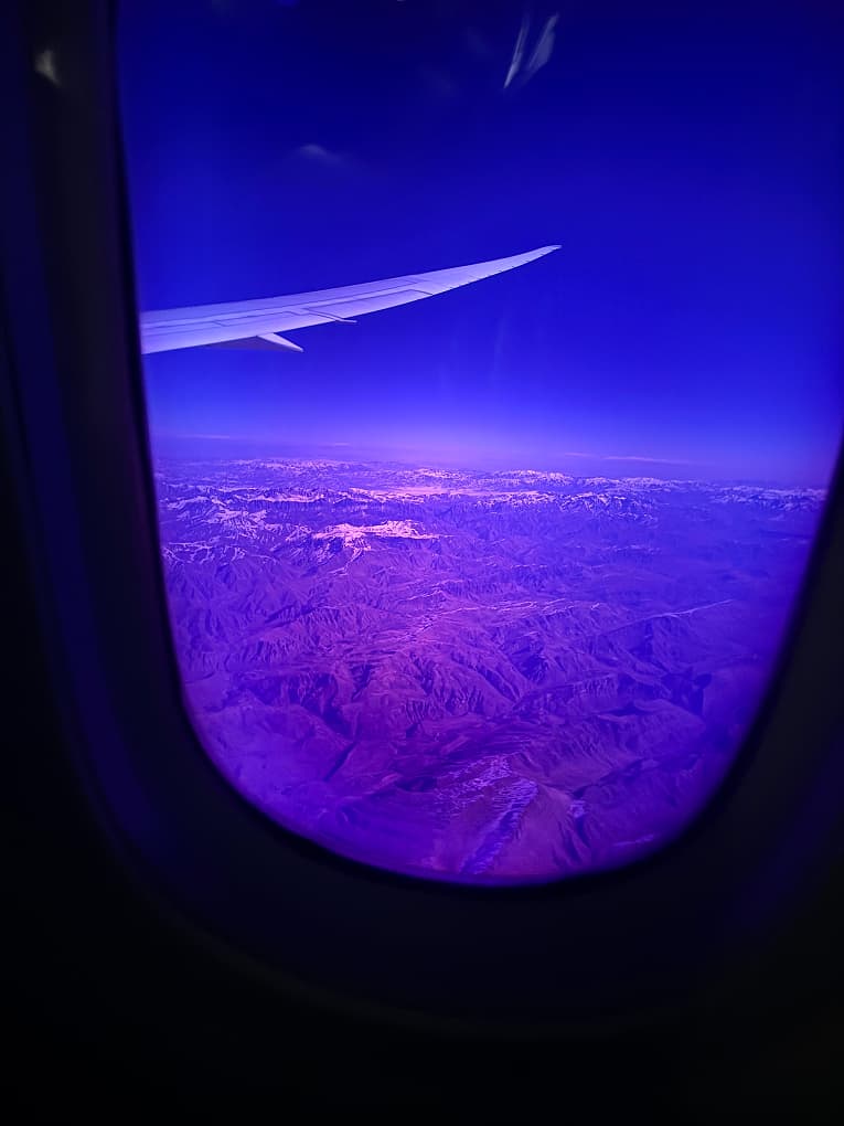 night view of city lights from an aeroplane window, wing in frame
