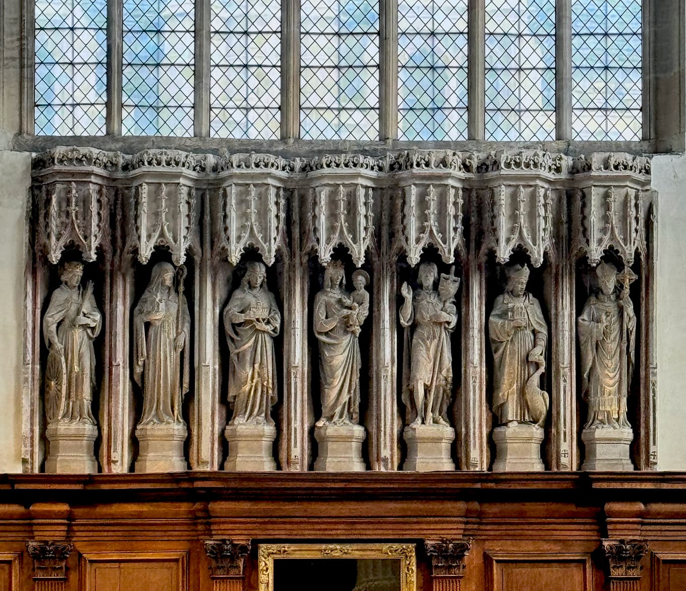 carved stone figures in gothic niches beneath a stained-glass window